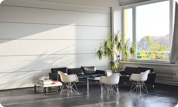 Bright modern living room with black sofas and white chairs