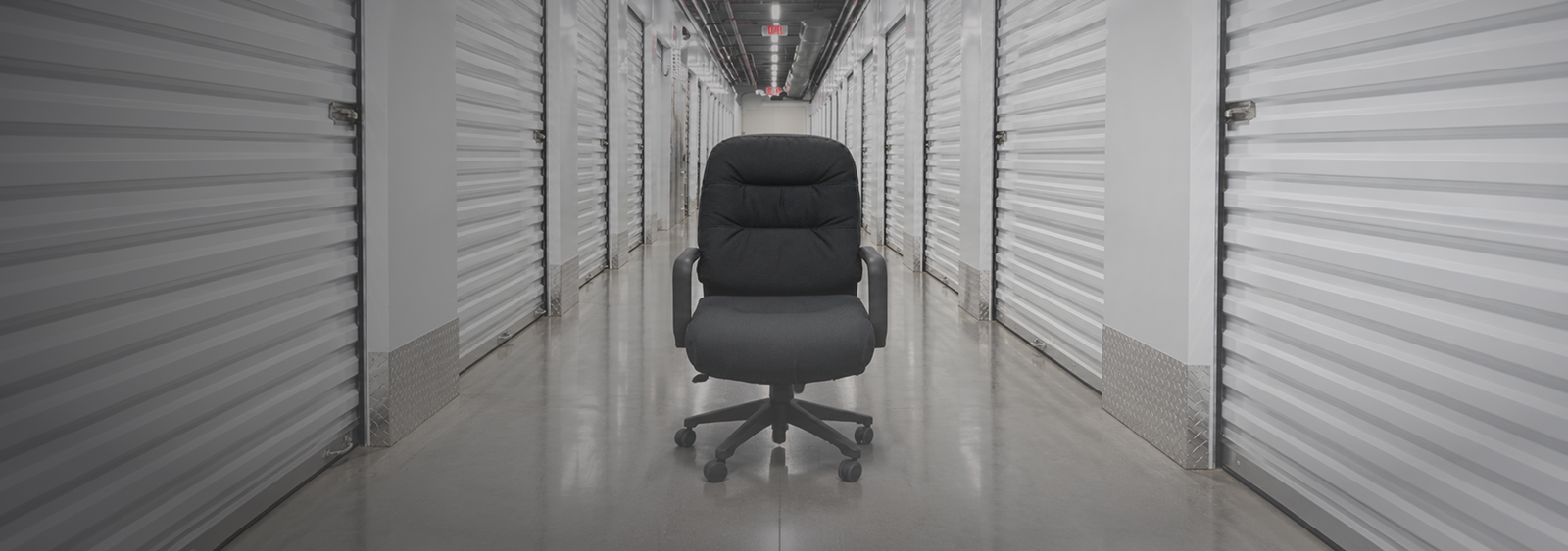 Black executive office chair in a modern storage hallway